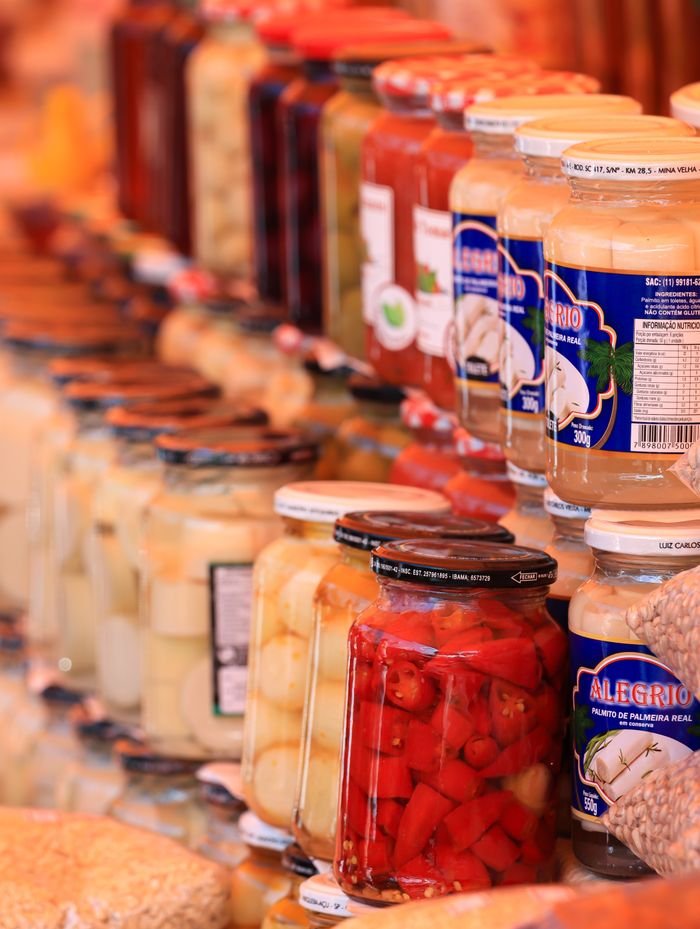 Colorful jars of preserved food neatly arranged in a vibrant market setting.